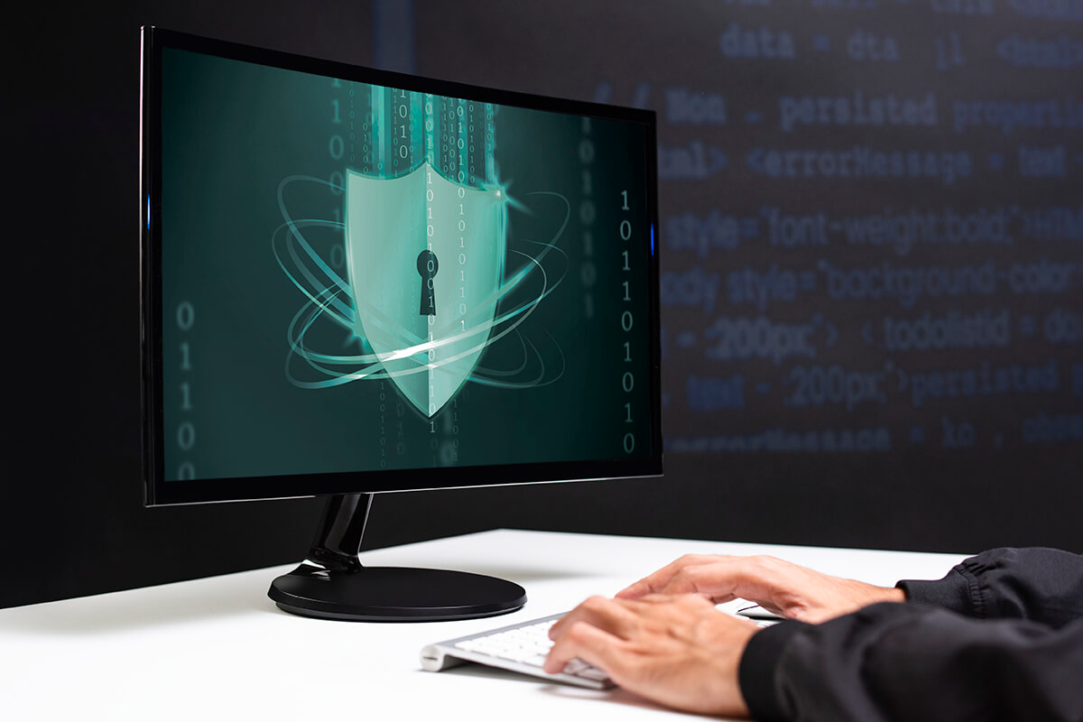 A person's hands on a keyboard and a monitor.