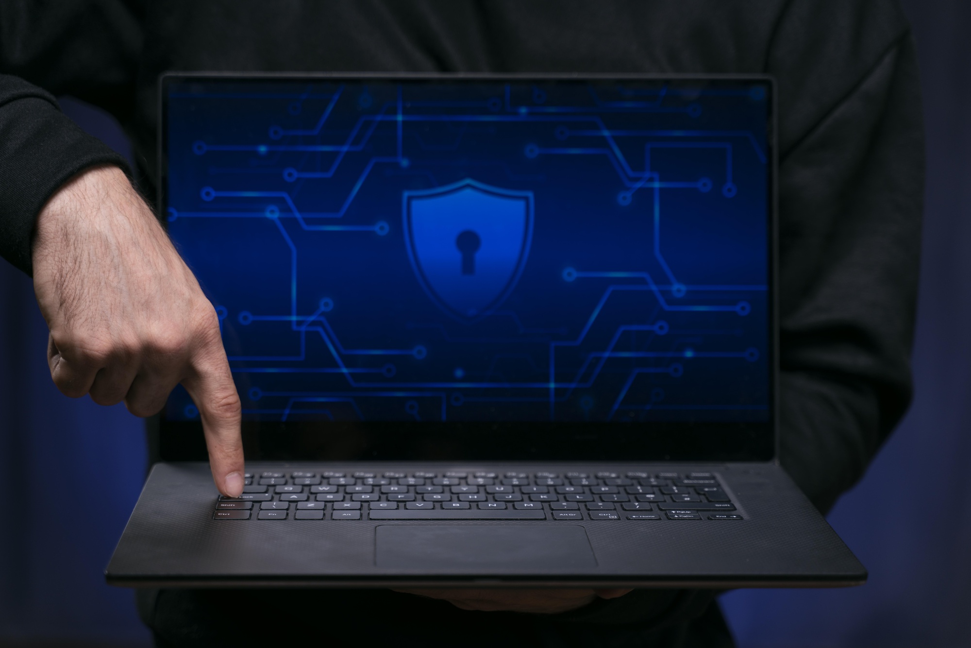 Close up of a finger pressing a button on a laptop with a padlock on the screen to start vulnerability assessments.